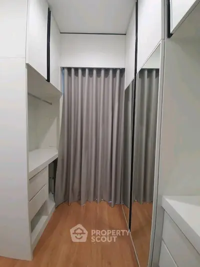 Modern storage room with sleek cabinetry and mirrored doors
