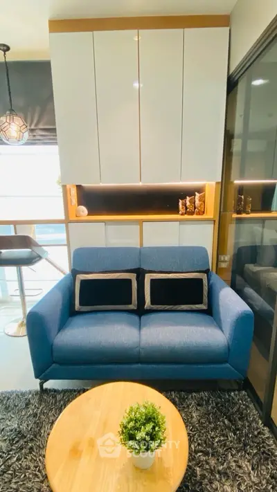 Modern living room with stylish blue sofa and sleek cabinetry