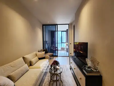 Modern living room with elegant decor and city view balcony, featuring a cozy sofa and sleek TV setup.