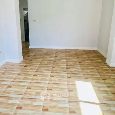 Spacious empty room with tiled flooring and natural light