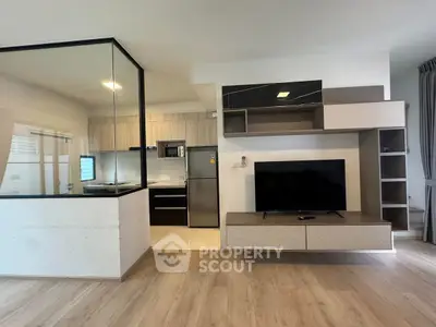 Modern open-concept living room with sleek kitchen and stylish TV unit