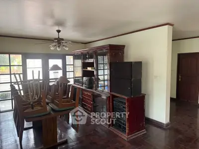 Spacious dining room with vintage wooden furniture and natural light.