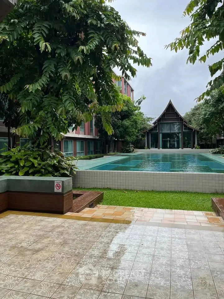 Stunning poolside view with lush greenery and modern architecture, perfect for relaxation and leisure.