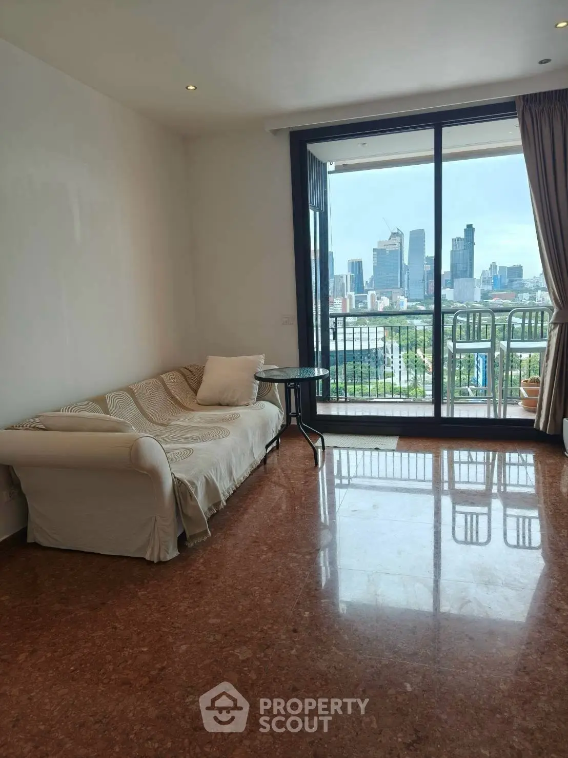 Spacious living room with city skyline view and elegant marble flooring.