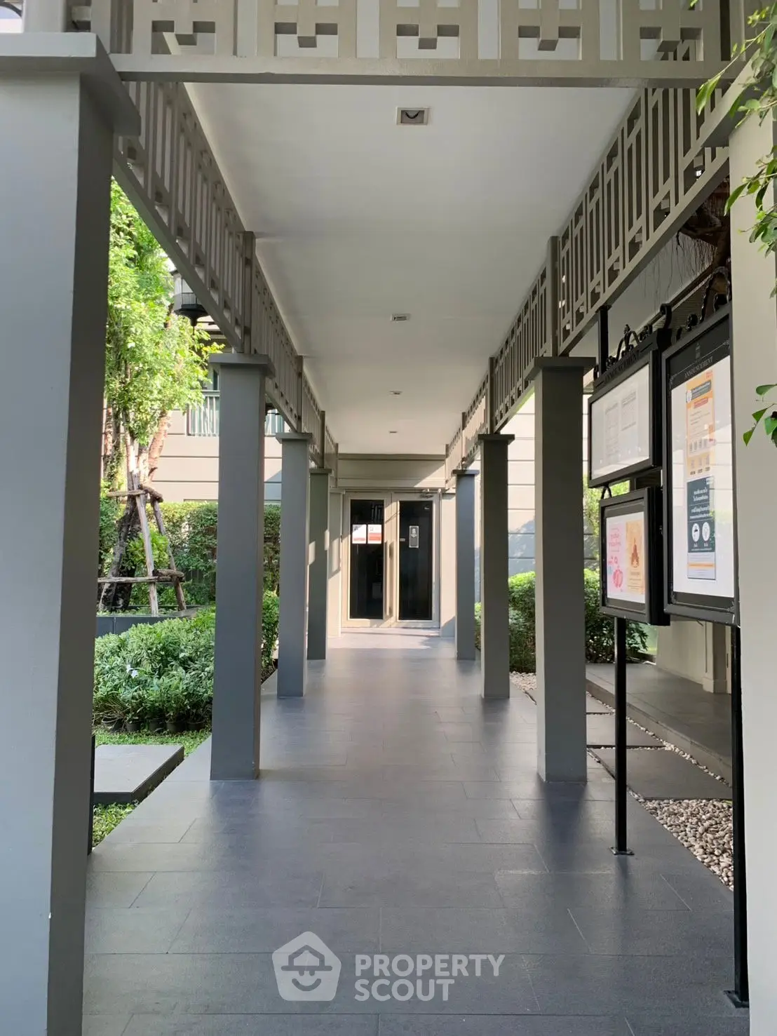Modern building entrance with sleek design and lush greenery