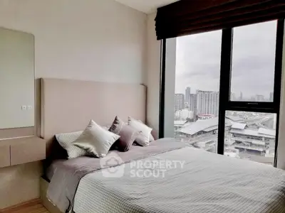Modern bedroom with large window offering city view, featuring stylish decor and comfortable bedding.