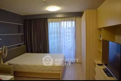 Modern bedroom with sleek design, large window, and built-in storage in a stylish apartment.