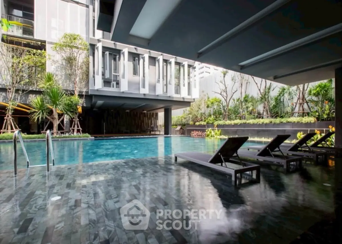 Luxurious modern apartment complex with stunning pool and lush greenery.