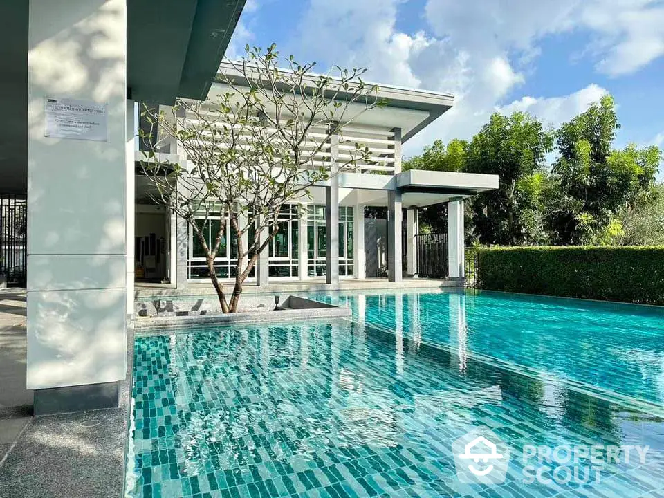 Luxurious modern home with stunning pool and lush greenery, perfect for relaxation and entertainment.