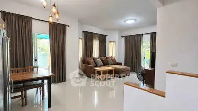 Spacious living room with modern decor and natural light, perfect for relaxation and entertainment.