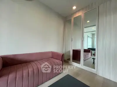 Modern living room with stylish pink sofa and mirrored wardrobe