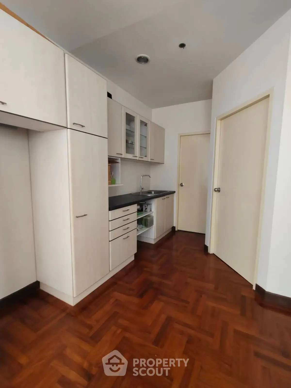 Modern kitchen with sleek cabinetry and wooden flooring