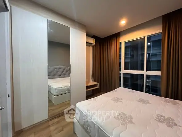 Modern bedroom with large window and mirrored wardrobe in stylish apartment