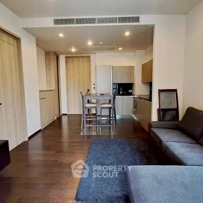 Modern open-plan living room with sleek kitchen and cozy seating area