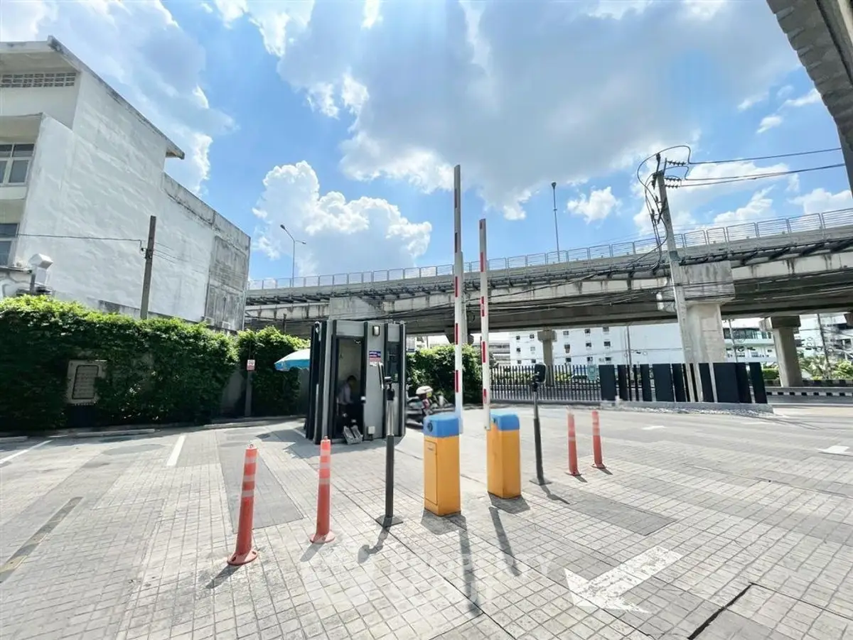 Spacious parking area with security booth under clear blue sky