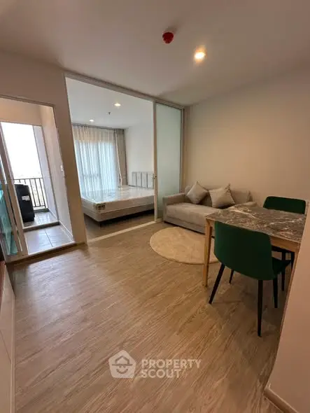 Modern apartment interior with cozy living area and bedroom, featuring wooden flooring and stylish furniture.