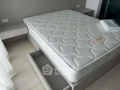 Spacious bedroom with modern bed and built-in storage drawers, perfect for urban living.
