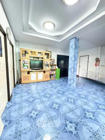 Spacious living room with unique blue patterned flooring and built-in entertainment center.