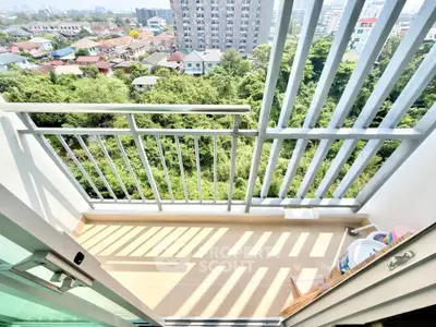 Charming balcony with lush green view in urban setting, perfect for relaxation and enjoying nature.