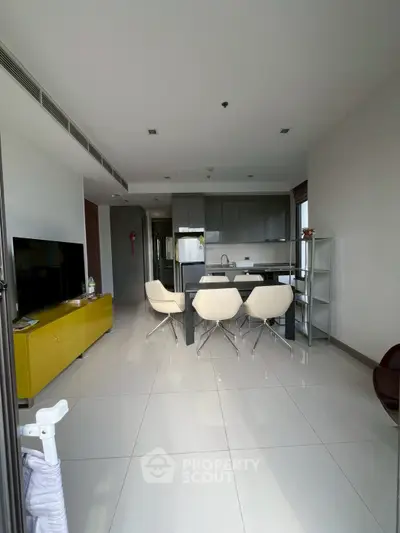 Modern open-plan living room with sleek kitchen and stylish furniture in a contemporary apartment.