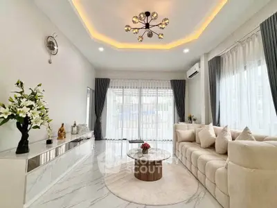 Luxurious modern living room with elegant decor and large windows.
