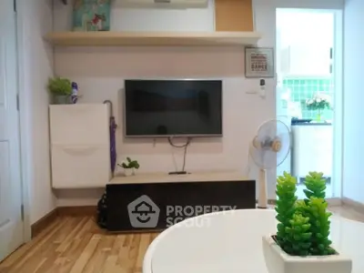 Modern living room with TV, wooden flooring, and stylish decor in a cozy apartment.