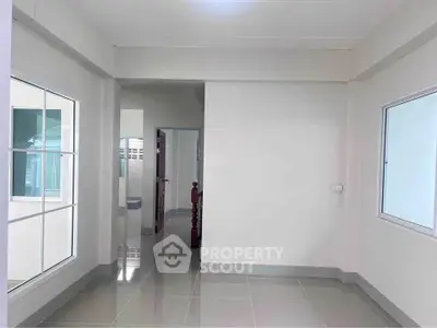 Bright and spacious interior hallway with modern design and large windows.