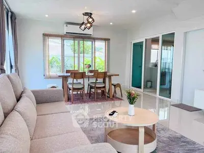Spacious living room with modern decor and natural light, perfect for relaxation and entertaining.