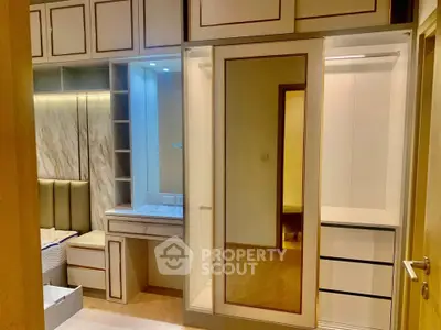 Luxurious bedroom with elegant built-in wardrobe and vanity in modern apartment.