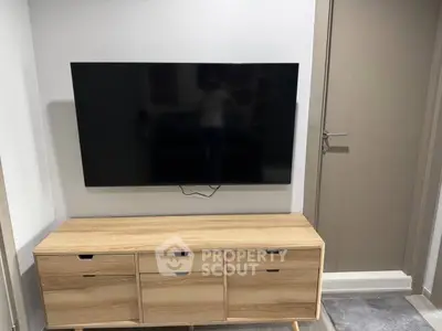 Modern living room with wall-mounted TV and stylish wooden cabinet