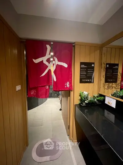 Elegant spa entrance with wooden paneling and red curtains, creating a serene atmosphere.
