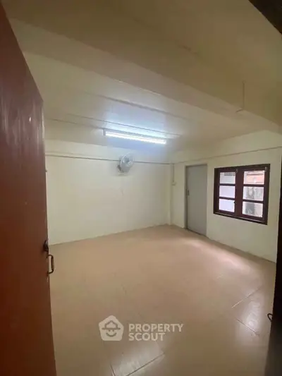 Spacious unfurnished room with tiled flooring and ceiling fan, ideal for customization.