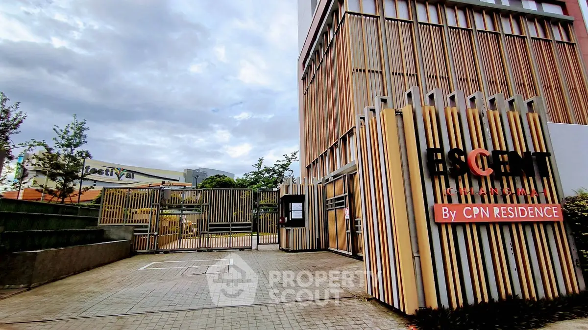 Modern residential building entrance with stylish wooden facade and secure gated access.