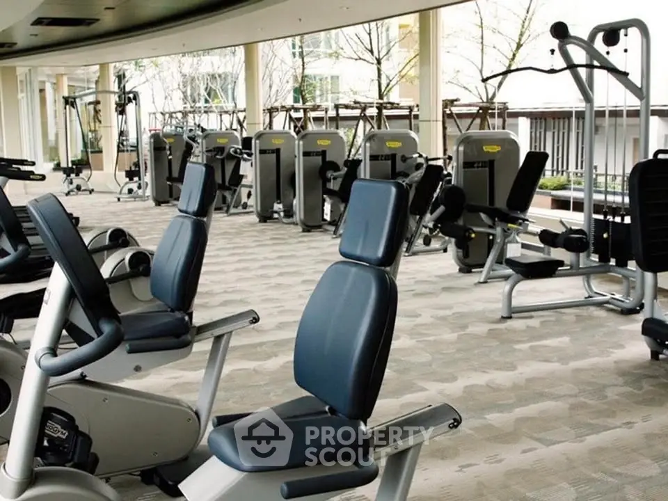 Spacious modern gym with state-of-the-art fitness equipment and large windows.