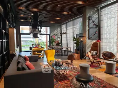 Spacious modern living room with stylish furniture and large windows offering natural light.