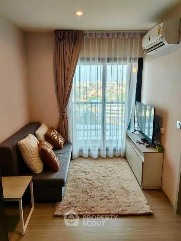 Cozy living room with modern decor and large window offering a scenic view.
