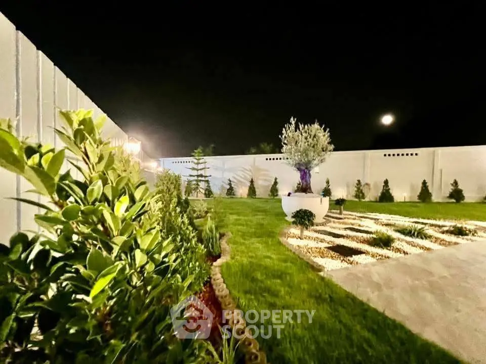 Stunning night view of a beautifully landscaped garden with lush greenery and ambient lighting.