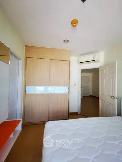 Spacious bedroom with modern closet and air conditioning in a stylish apartment.