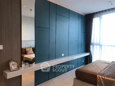 Modern bedroom with stylish blue accent wall and large window