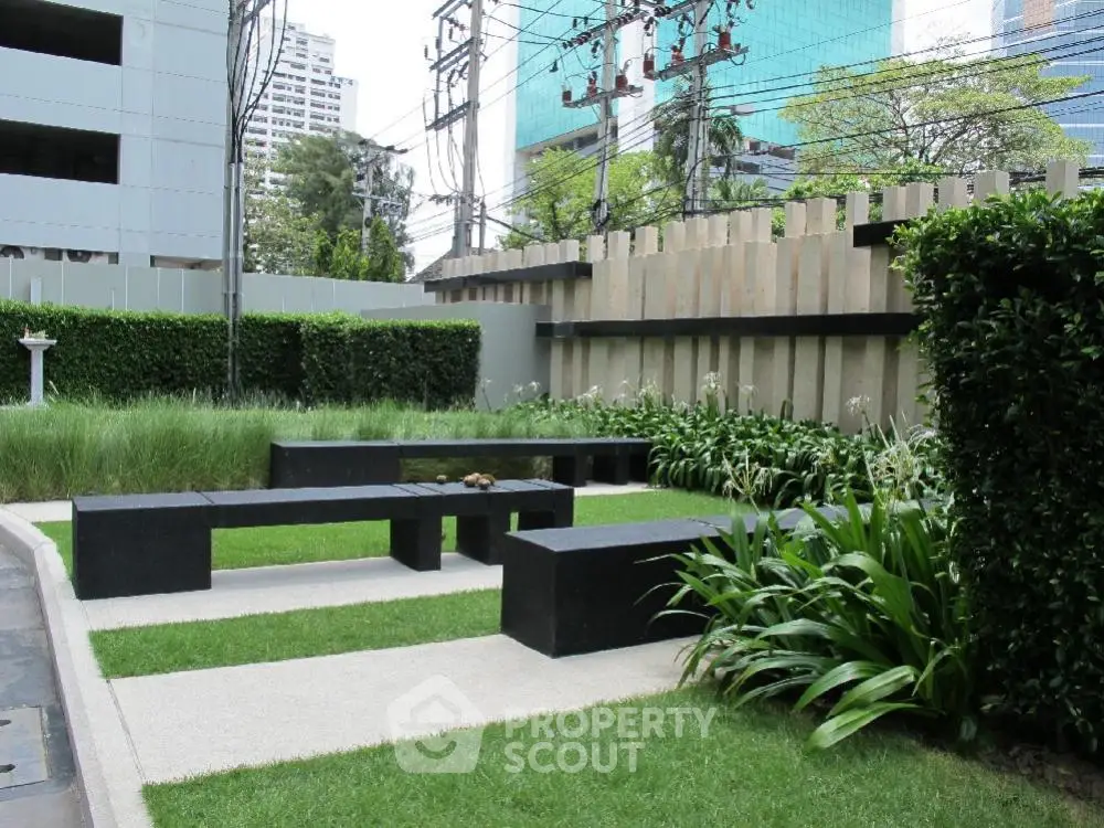 Modern garden area with sleek benches and lush greenery in urban setting