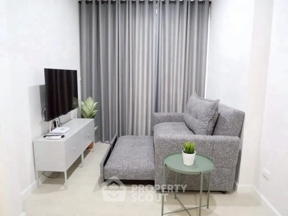 Cozy living room with modern gray sofa and TV setup