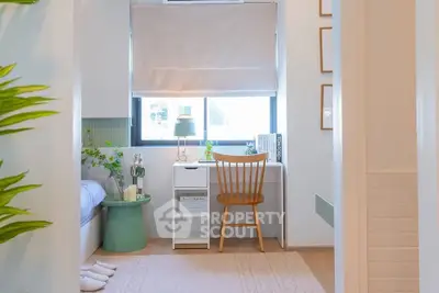 Charming bedroom with cozy study nook and natural light, perfect for relaxation and productivity.