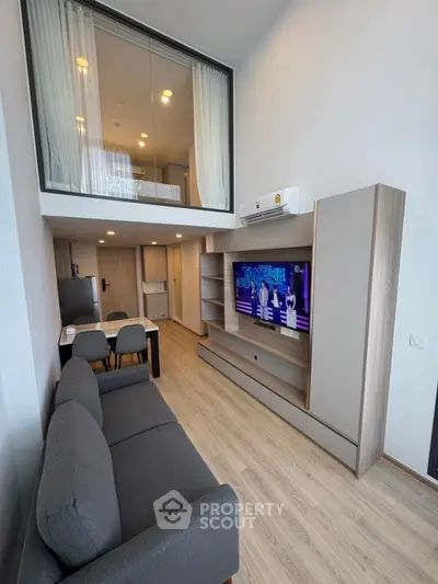 Modern loft-style living room with mezzanine bedroom and sleek furniture.