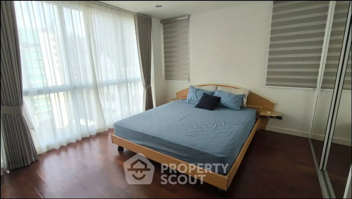 Spacious bedroom with large windows and modern decor