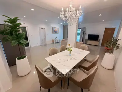 Elegant open-plan living and dining area with chandelier and modern decor