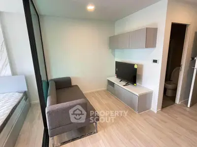 Modern compact living room with sleek furniture and TV setup