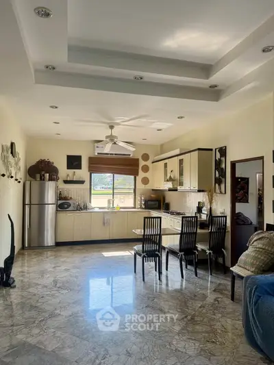 Spacious kitchen with dining area, featuring modern appliances and elegant marble flooring.