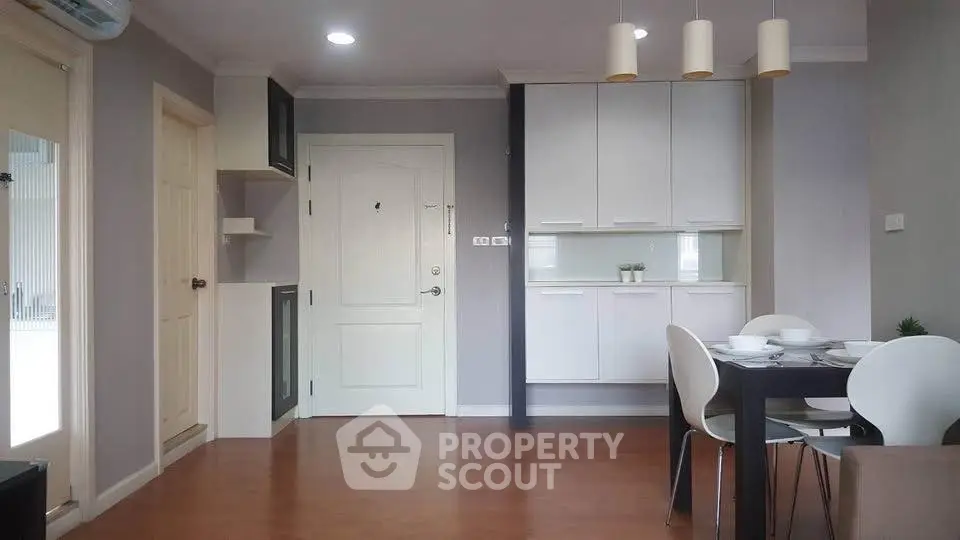 Modern apartment interior with dining area and stylish kitchen cabinets.