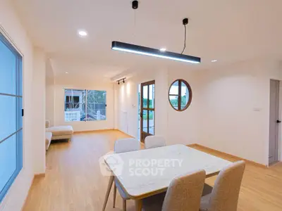 Spacious modern living room with elegant dining area and large windows for natural light.