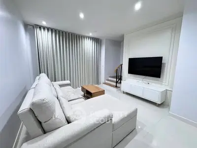 Modern living room with sleek white sofa and wall-mounted TV